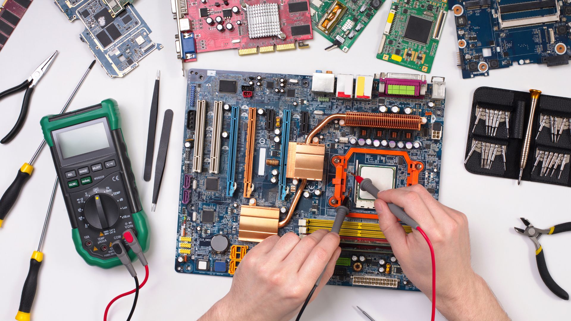 Technicien en micro-soudure travaillant sur une carte mère d'ordinateur à Paris